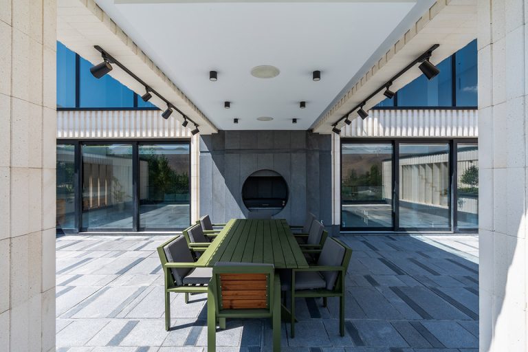 میز غذاخوری فضای باز در ویلای شهرک آنا در رودهن با طراحی مدرن و نمای سنگی