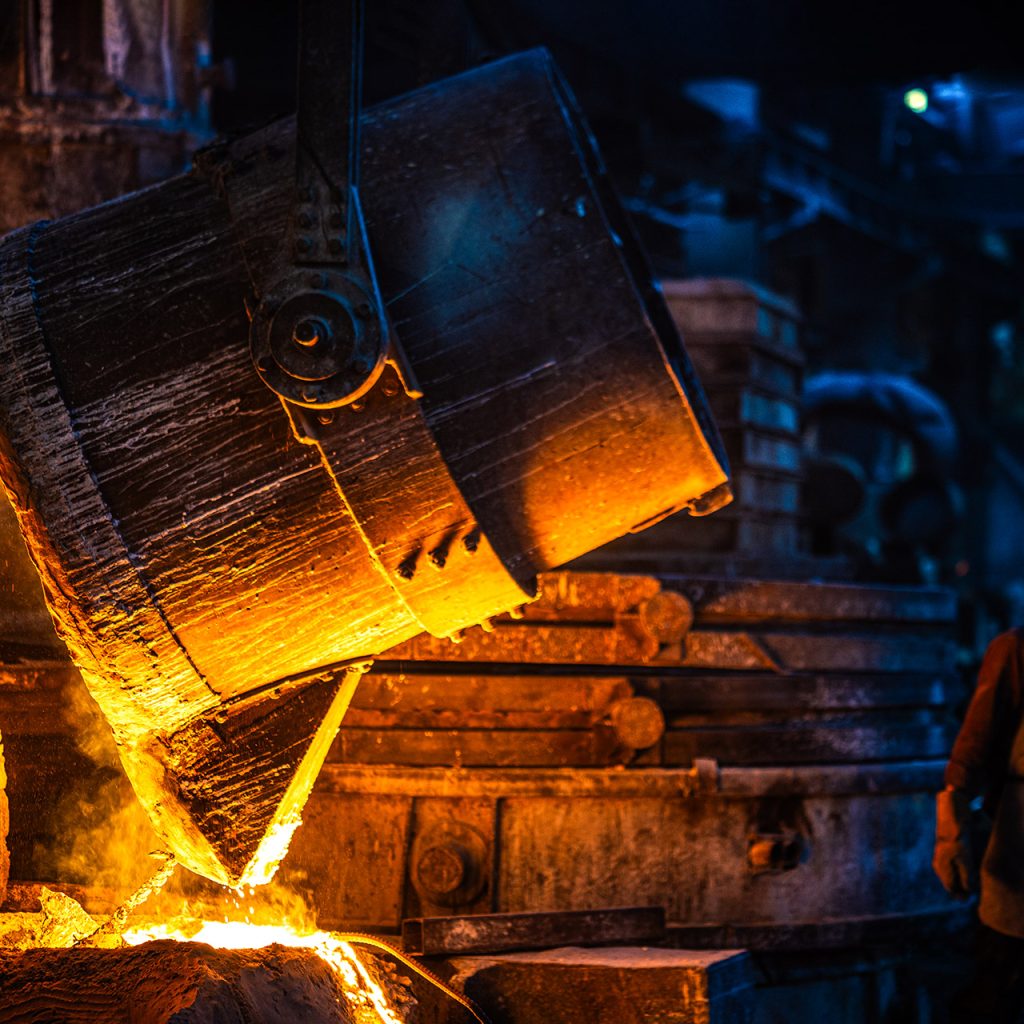 بوته بزرگ ریخته‌گری در حال تخلیه مواد گداخته در فضای صنعتی