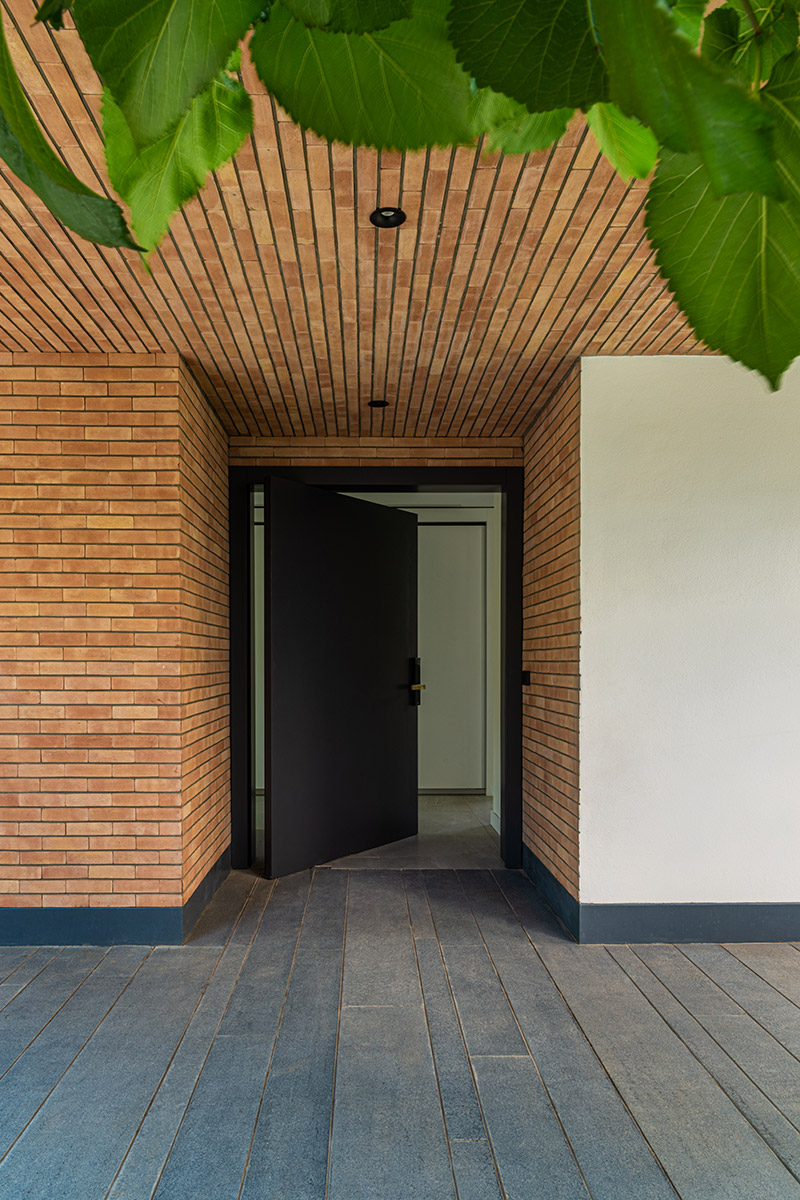 نمای ورودی ویلای کاتوزیان با طراحی مینیمال و مصالح آجر و رنگ‌های طبیعی، طراحی توسط NOIR،