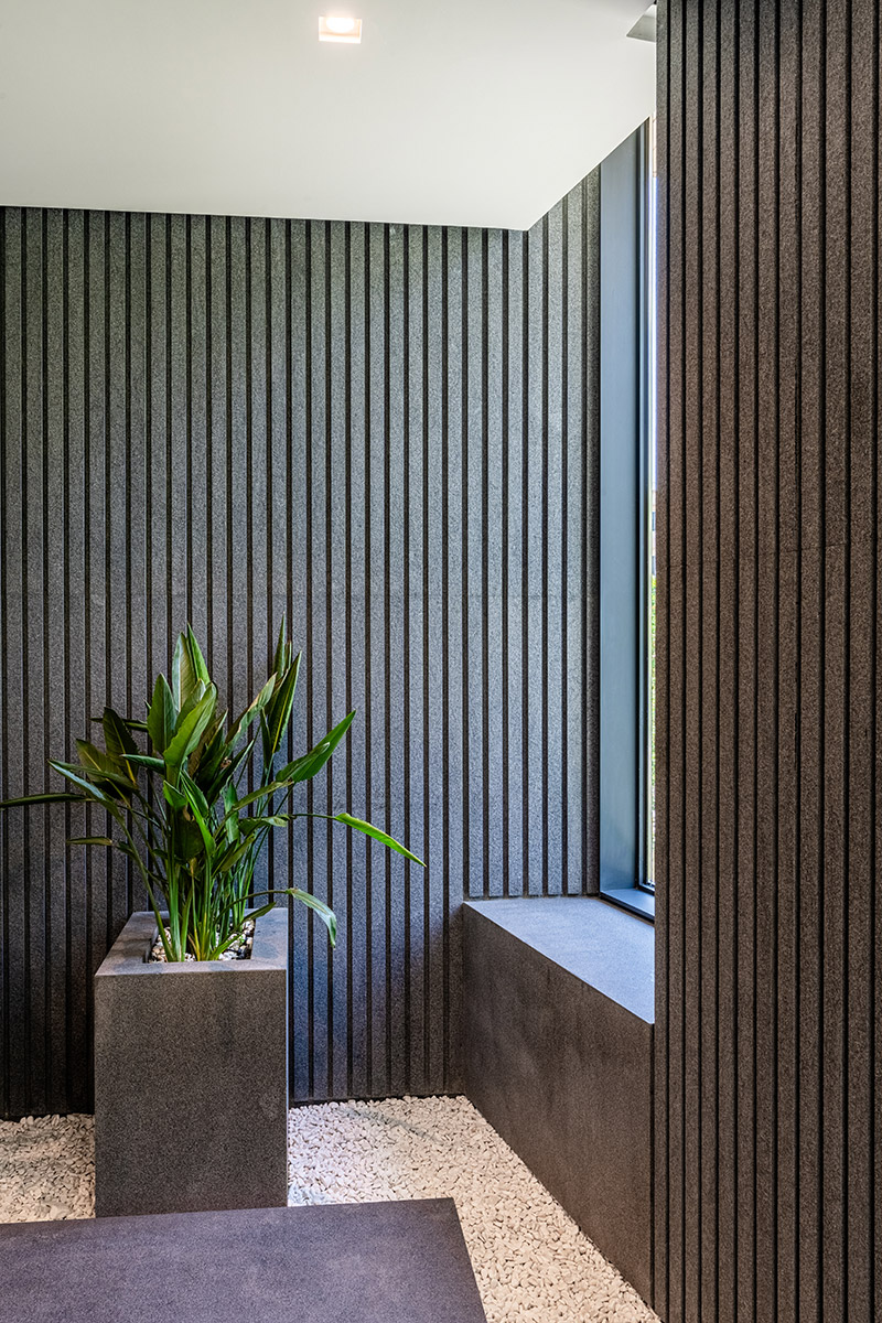 فضای داخلی ساختمان لومن با طراحی مدرن و استفاده از پوشش دیواری تیره و نورپردازی سقفی