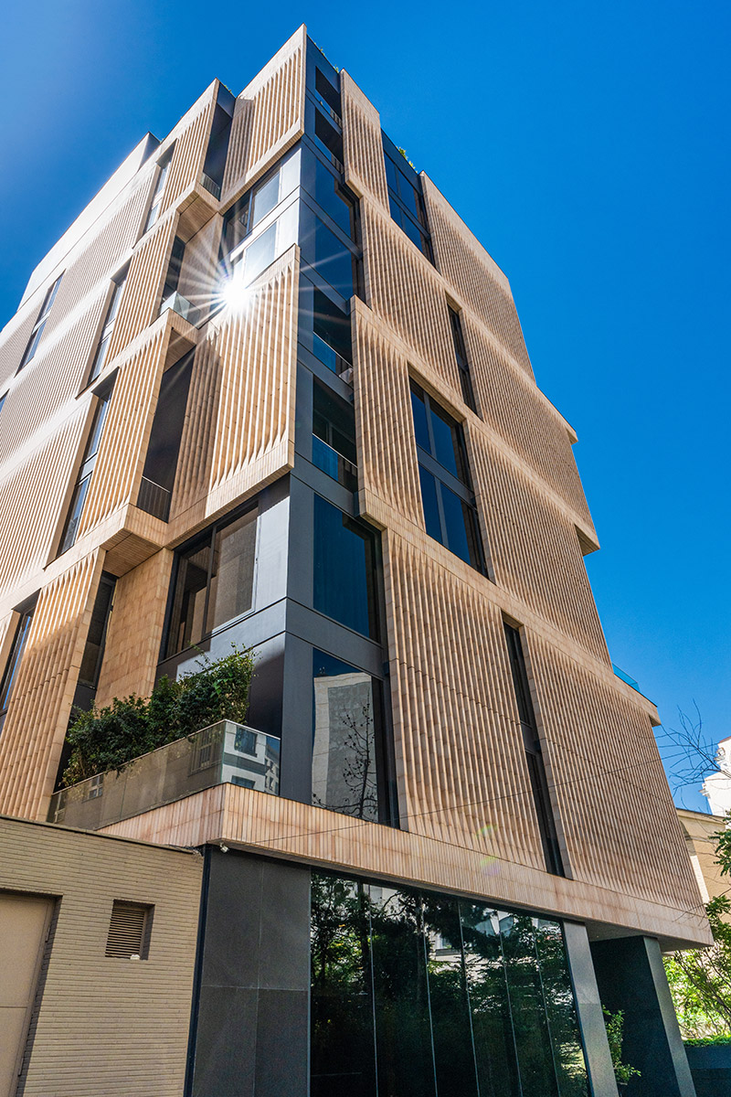 ساختمان لومن از زاویه پایین با نمایش ساختار پلکانی و مصالح متنوع