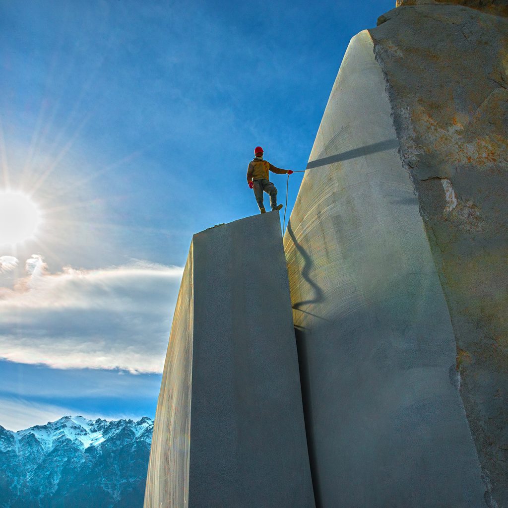 کارگر معدن گرانیت در قاب دراماتیک با نور خورشید در پس‌زمینه – عکس از حمید خرمی