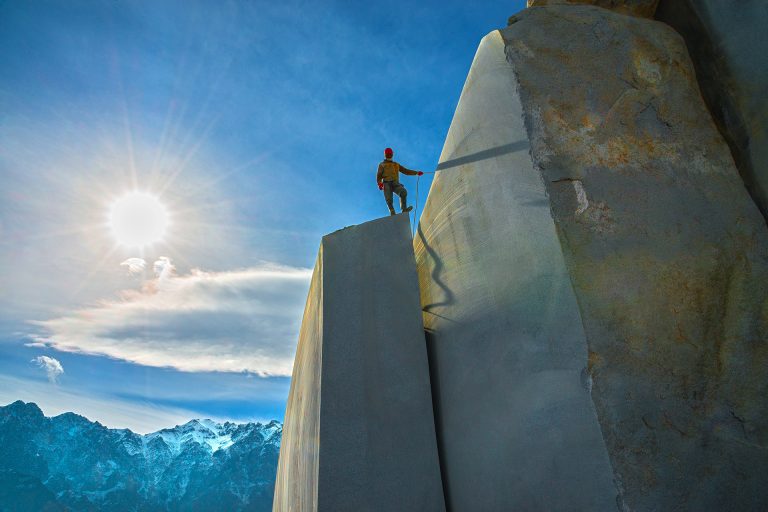 کارگر معدن گرانیت در قاب دراماتیک با نور خورشید در پس‌زمینه – عکس از حمید خرمی