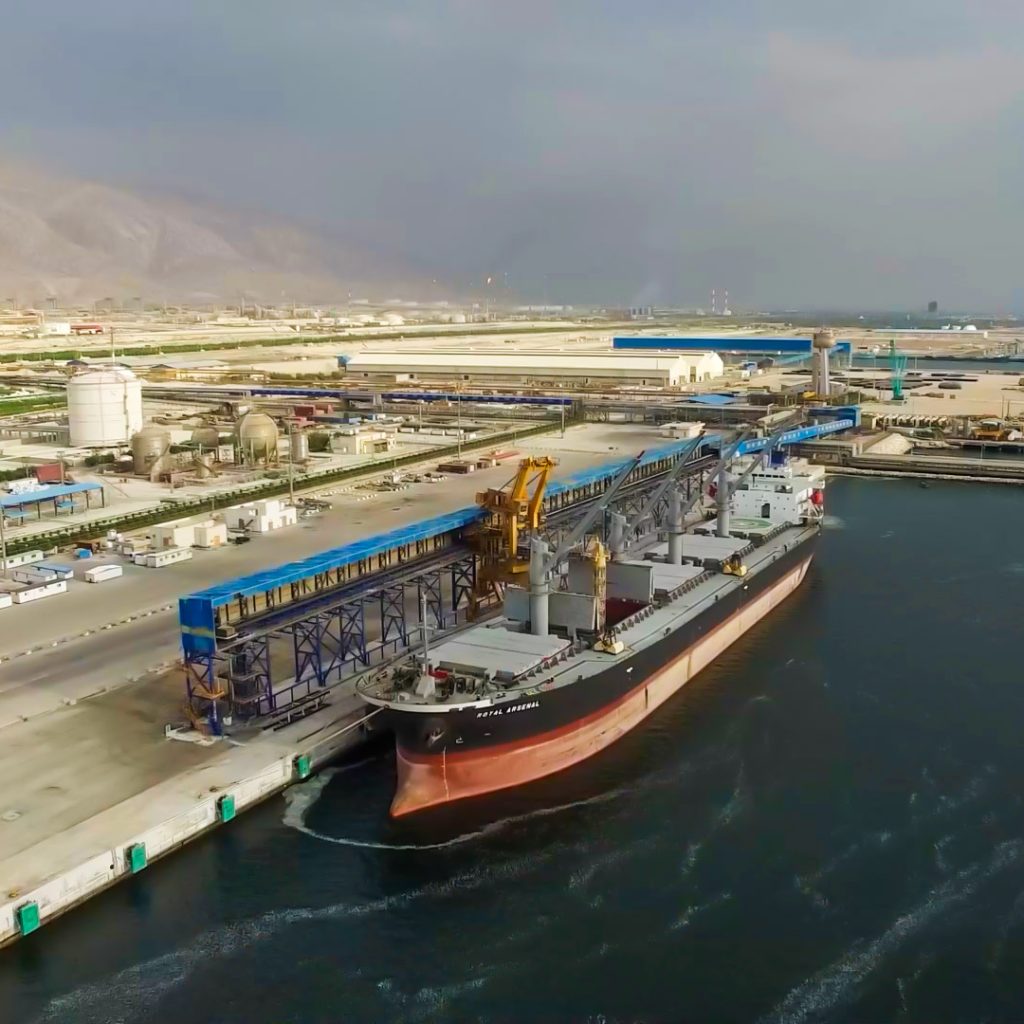 تصویر هوایی بندر و کشتی در حال بارگیری، مرتبط با فعالیت‌های حمل‌ونقل شرکت نگین کیش