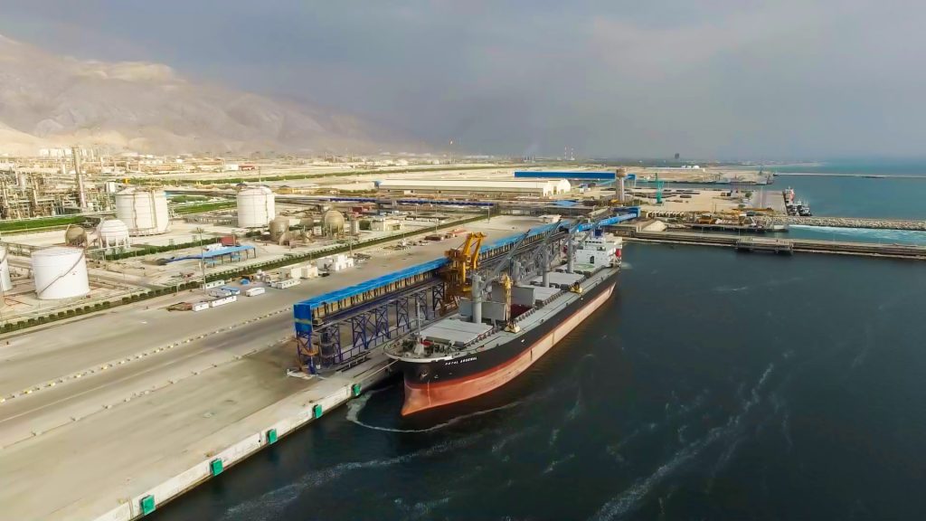 تصویر هوایی بندر و کشتی در حال بارگیری، مرتبط با فعالیت‌های حمل‌ونقل شرکت نگین کیش