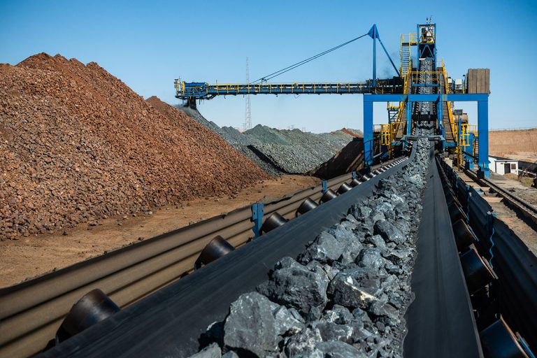 نمای نزدیک از نوار نقاله بارگیری سنگ آهن خام در کارخانه