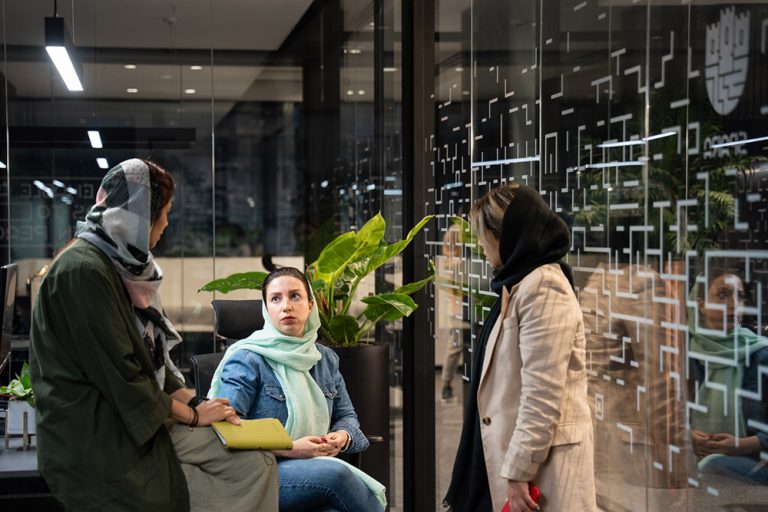 سه نفر از کارکنان زن در حال گفت‌وگو در فضای باز داخلی شرکت اسپارا